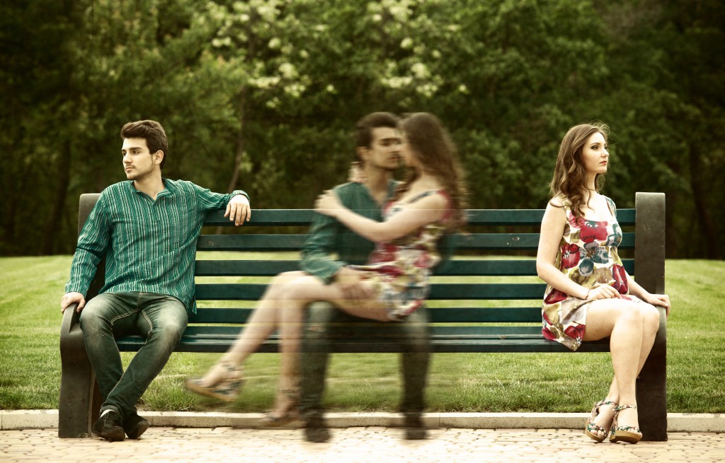 Couple sitting apart on bench and remembering their love story